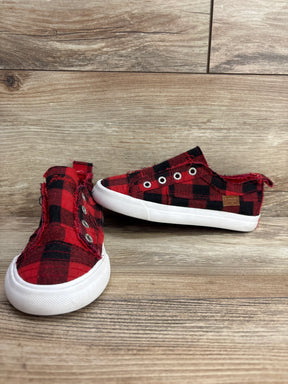 Pair of red and black plaid slip-on toddler shoes with white rubber soles on wooden surface