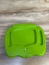 Green plastic toy base with screws and switch on wooden surface