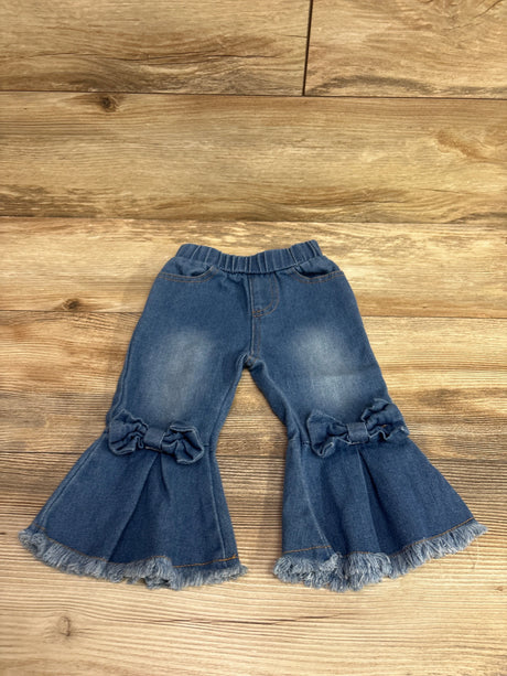 Front view of Psainyal blue bell bottom jeans, size 6-12m, with ruffled knees and frayed hems on wood flooring