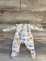 Flat-lay of Old Navy newborn 0-3M beige footed sleeper with rainbow and cloud print and ruffle shoulders on wood floor