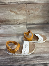 Angled top view of Cat & Jack Blair toddler sandals showing tan ankle straps and white crocheted toe bands on wood floor
