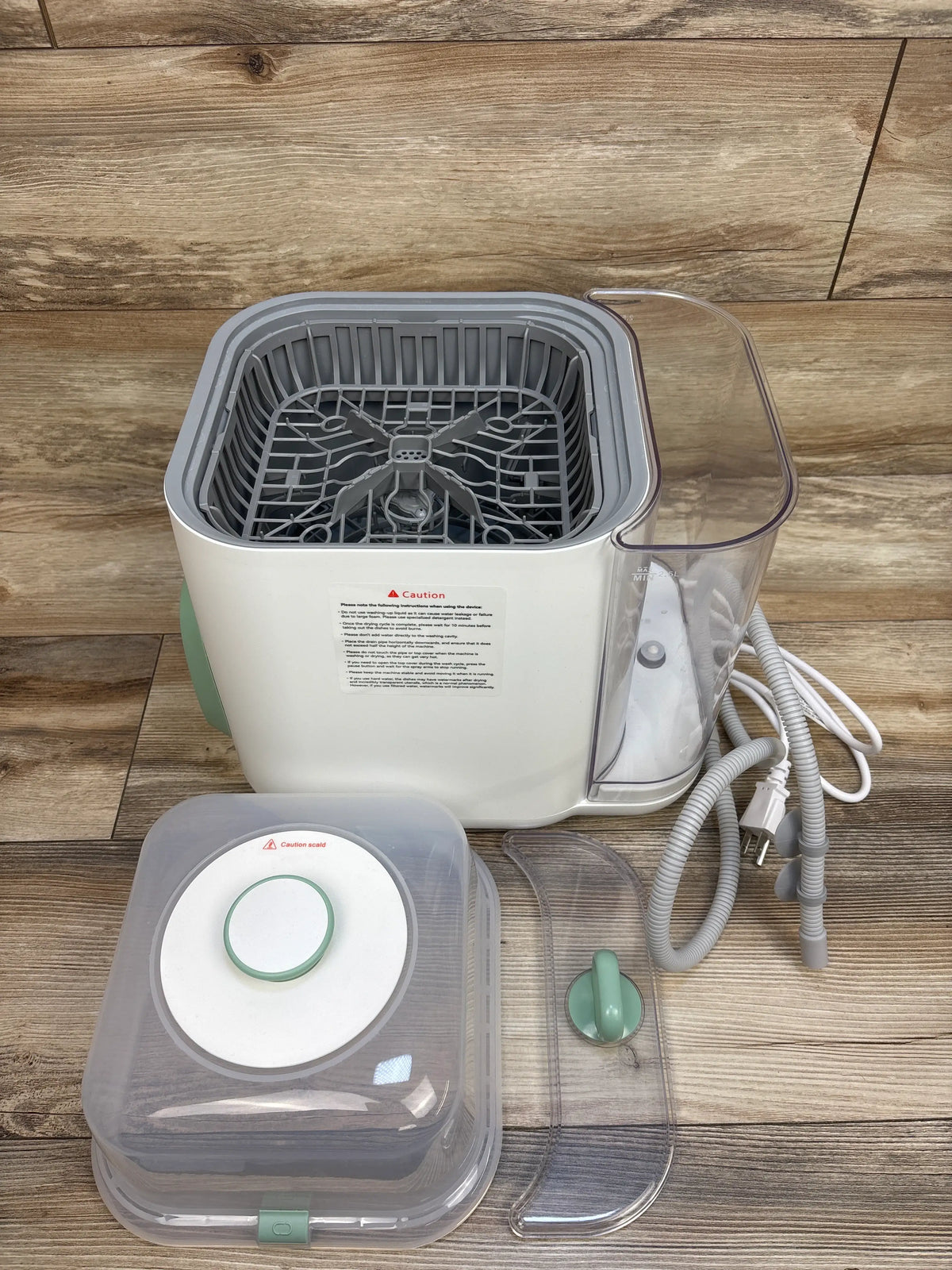 Top view of Momcozy KleanPal Pro bottle washer, sterilizer and dryer showcasing open rack, tank, hoses, and accessories
