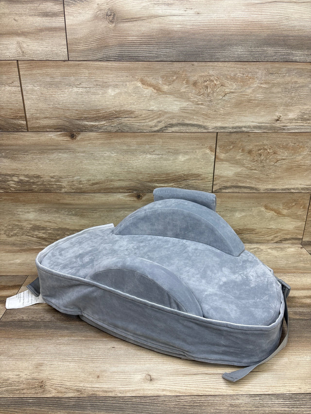 Three-quarter view of Momcozy CozyPro Nursing Pillow in Grey with raised support cushions on wood