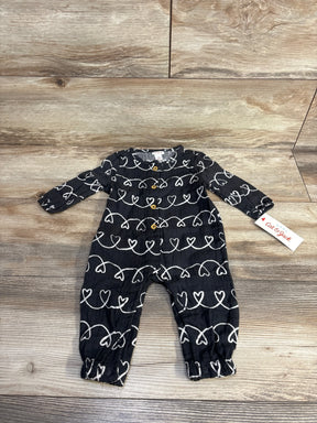 Black baby romper with white heart pattern and wooden buttons on wood floor, Cat & Jack tag
