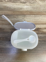 Top view of Termichy baby formula dispenser showcasing open lid and included scoop on wood-grain tabletop