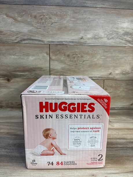 Huggies Skin Essentials size 2 diaper box for babies, 84 count, on wood floor