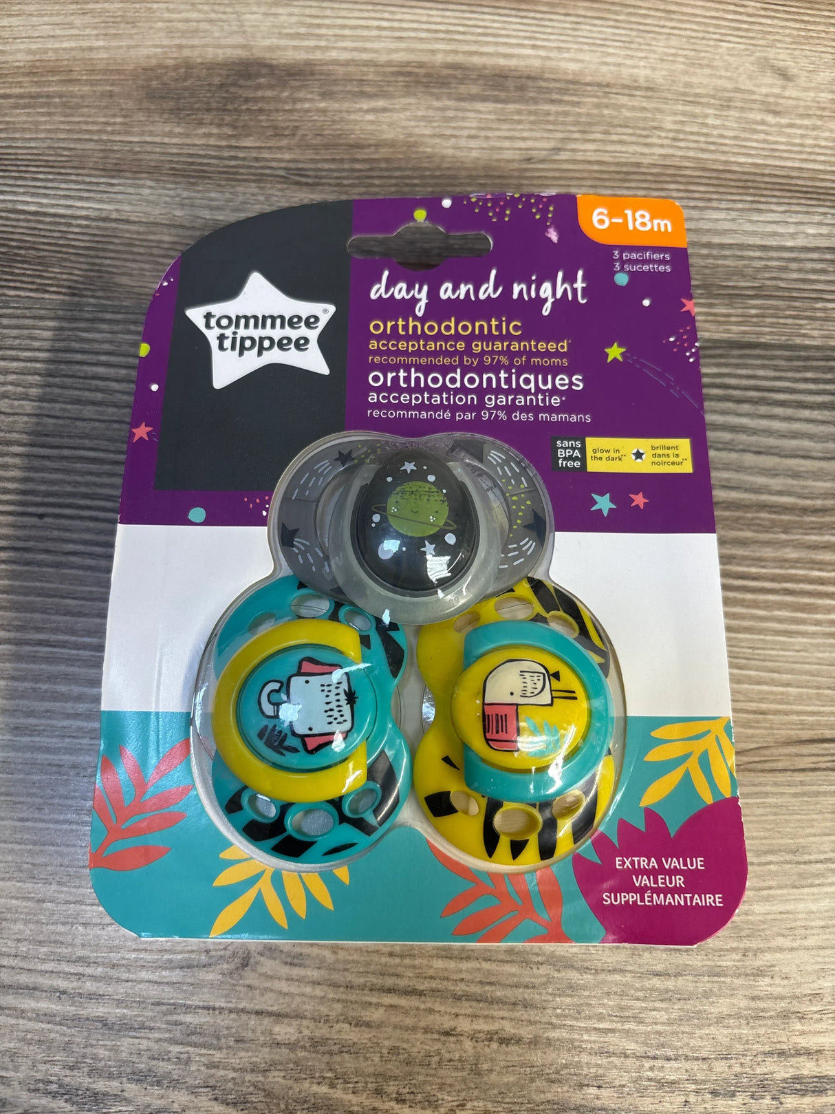 Tommee Tippee day and night orthodontic pacifiers for 6-18 months, set of three, on wood background