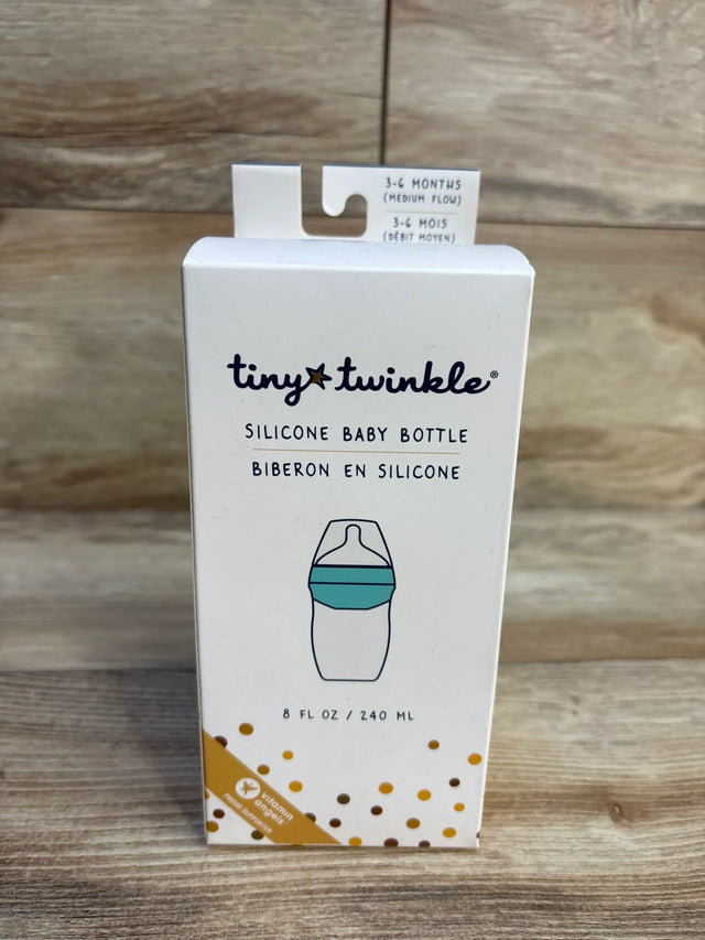 Front view of Tiny Twinkle silicone baby bottle box with teal band, 8 fl oz and medium flow (3-6 months) on wood background