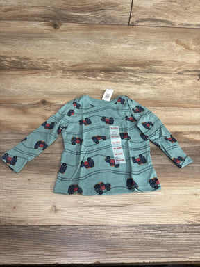 Blue long sleeve toddler shirt with red truck pattern, size 18-24 months, on wood background