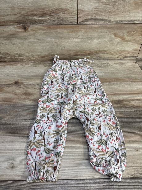 Flat lay of Old Navy sleeveless tie-knot jumpsuit in cream showcasing gathered elastic waist and elastic ankle cuffs on wood background