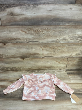 Pink and white tie-dye toddler sweater with ruffle detail on wooden background