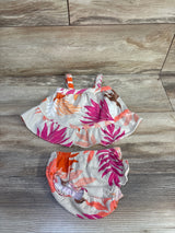 Top down view of Carter's beige 2 piece floral textured tank and bottoms with ruffle hem and straps on wood background
