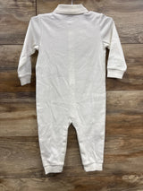Back view of a white long sleeve baby romper on wood background