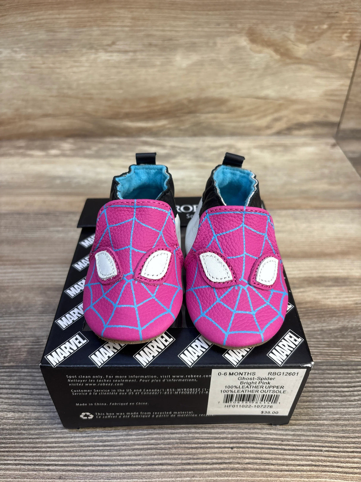 Bright pink Spider-Man baby shoes with blue web design, 0-6 months, leather, on Marvel box