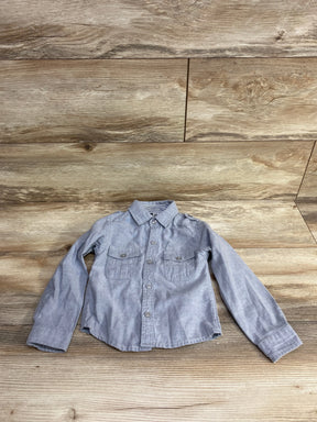 Light gray long sleeve toddler button-up shirt with chest pockets on wood background