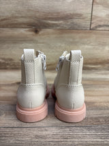 Pair of cream-colored children's boots with pink soles on wood floor background