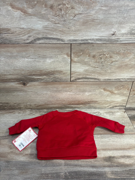 Back view of red Disney Baby Mickey Mouse sweatshirt (3-6 months) showing long sleeves and original tag on wood background
