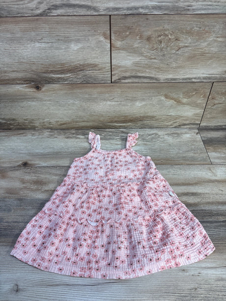 Flat lay of Rabbit + Bear pink floral tiered toddler dress showing ruffled tiers and ruffled shoulder straps on light wood floor