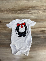 White baby onesie on wooden surface with cartoon design of black character wearing red bow