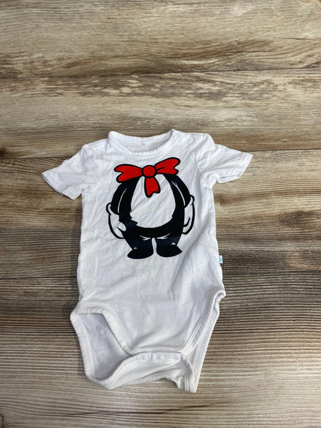 White baby onesie on wooden surface with cartoon design of black character wearing red bow