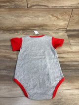 Back view of gray toddler bodysuit with red short sleeves and red trim, size 24 months, laid flat on wood floor showing snap bottom area