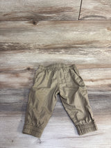 Back view of tan baby poplin pull-on pants with elastic waistband and cuffs and a back patch pocket on wood floor