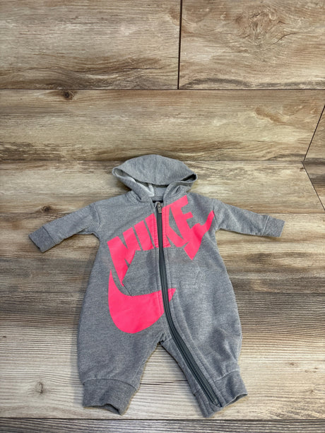 Gray hooded baby romper with pink logo and zipper front on wood background
