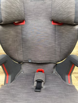 Front view of UPPAbaby Alta V2 High Back Booster Car Seat in Greyson showcasing gray upholstery and red side accents on a wood floor