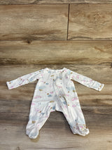 Flat lay of Just One You white ocean-print sleeper showing front zipper, long sleeves, and enclosed feet on wood background