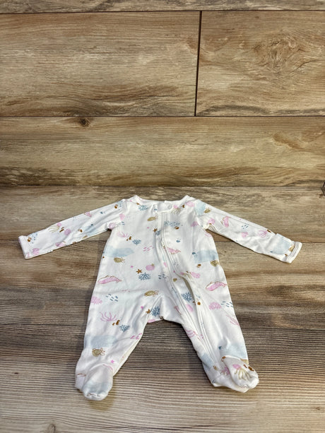 Flat lay of Just One You white ocean-print sleeper showing front zipper, long sleeves, and enclosed feet on wood background