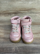 Pair of pink toddler sneakers with white laces and Velcro straps on wood floor