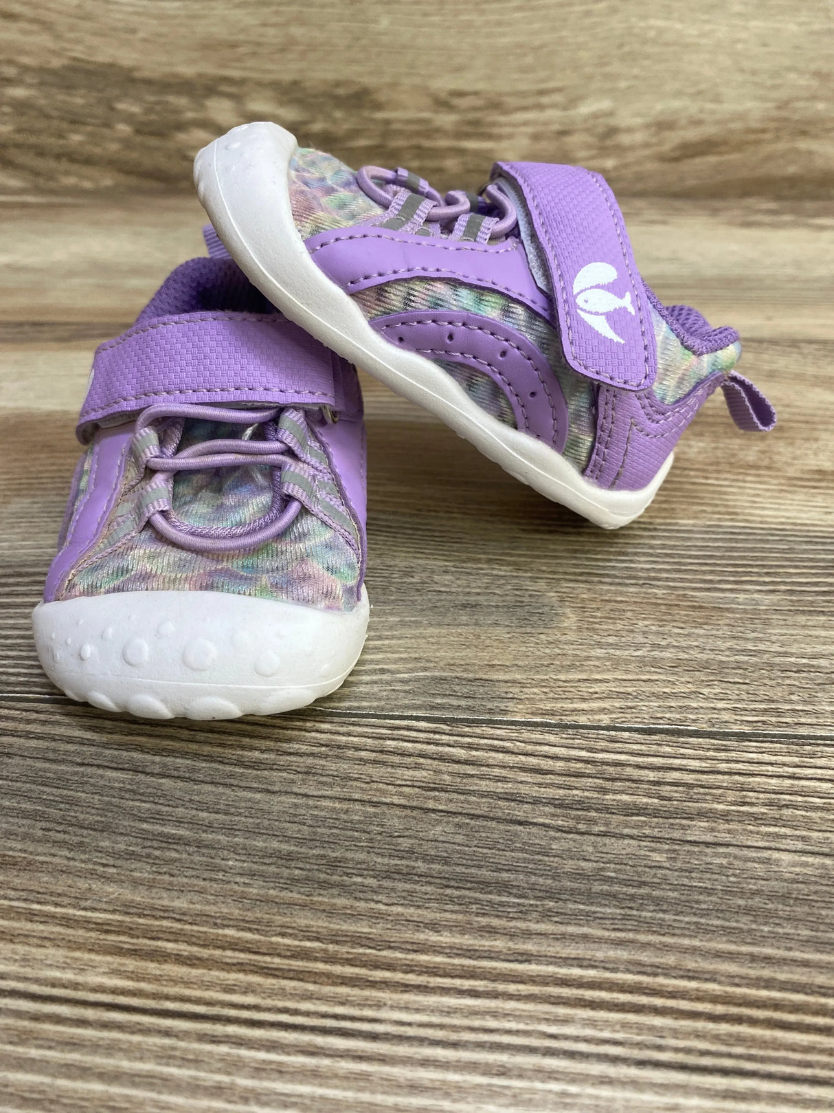 Front and side view of purple barefoot water shoes size 4/5C showing velcro strap, patterned knit upper and white sole on wood