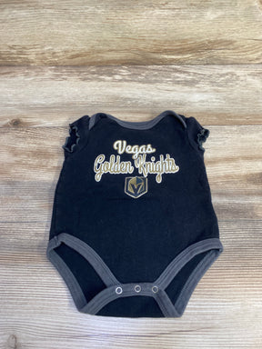 Flat lay of black ruffle sleeve bodysuit with Vegas Golden Knights text and logo, three snap closures on wood background