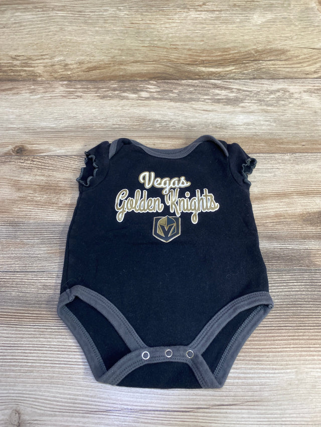 Flat lay of black ruffle sleeve bodysuit with Vegas Golden Knights text and logo, three snap closures on wood background