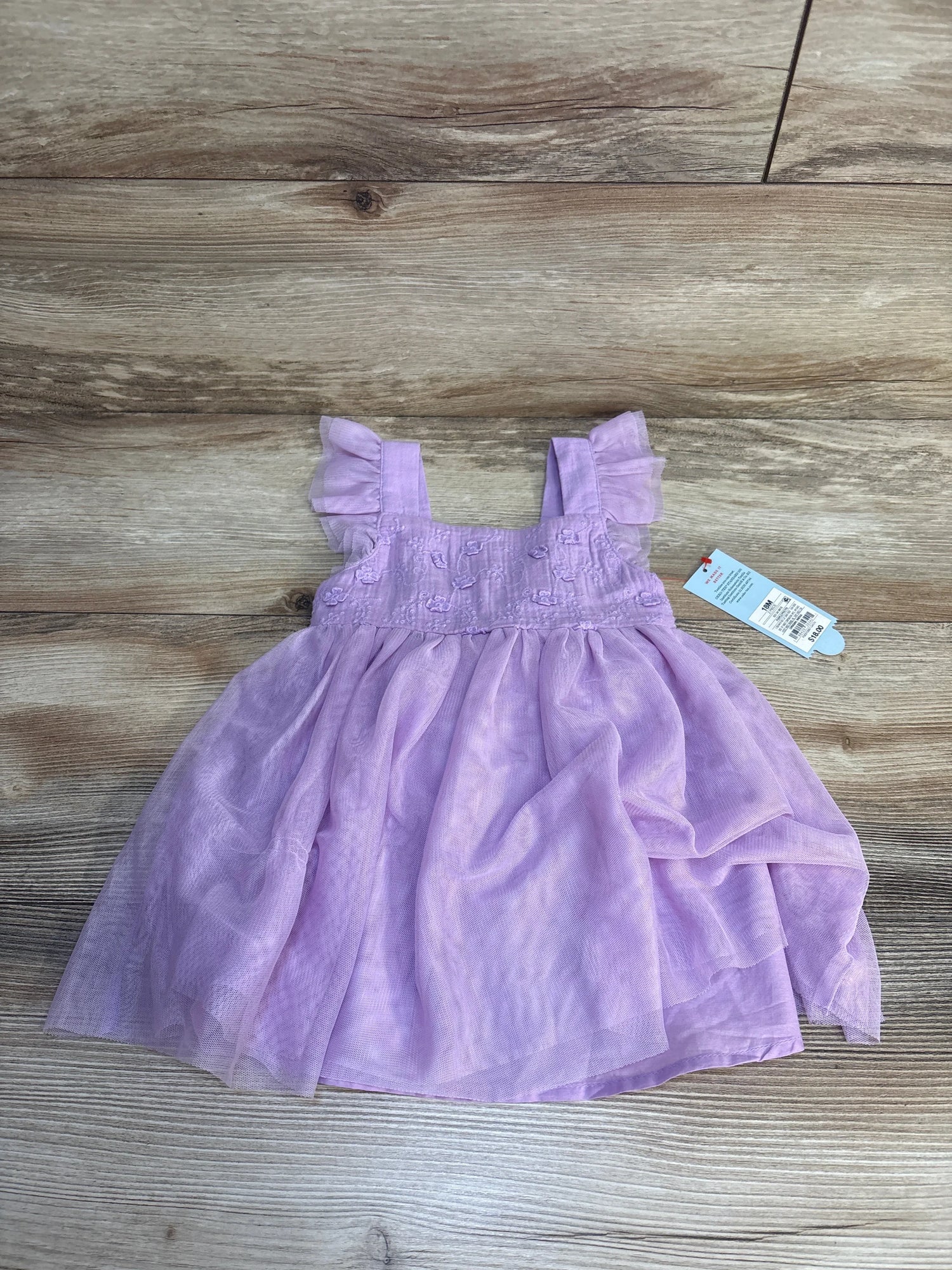 Light purple toddler dress with ruffled sleeves, displayed on wood background, resale kids clothes