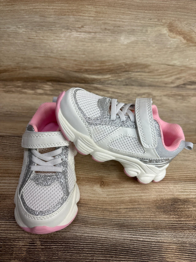 Front and side view of Carter's white toddler athletic sneakers size 9C showing pink lining and silver glitter accents on a wood background