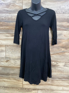 Front of black maternity swing top with three quarter sleeves and crossed strap V neck on mannequin wood background