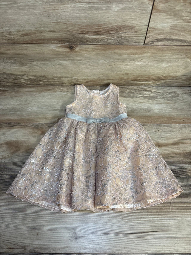 Pink lace toddler dress with silver floral embroidery and a satin bow, displayed on wood floor