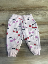 Pink baby jogger pants with red and purple cherry print on wood background