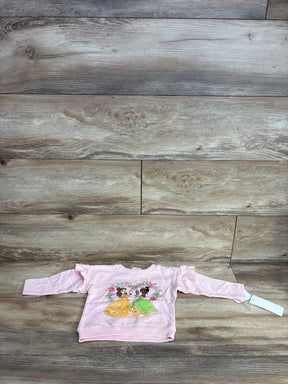 Front view of pink baby sweatshirt (3-6m) showcasing Belle and Tiana graphic and ruffled shoulders on wood floor