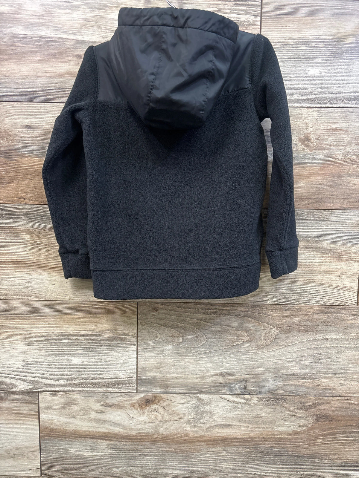 Back view of Nike Sportswear black full-zip fleece jacket in size 4-5T showcasing hood and fleece texture on wood flooring