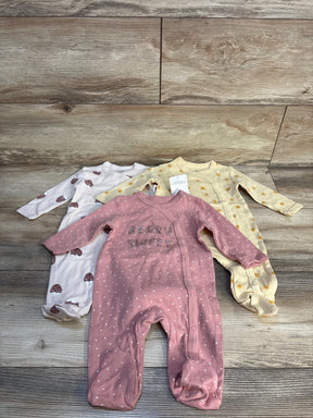 Front view of 3 Kiddiezoom footed sleepers in mauve, cream, yellow; mauve reads BERRY SWEET, printed patterns, on wood floor