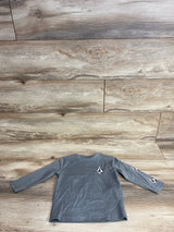 Gray long-sleeve kids shirt with black and white diamond logo on chest and sleeve, wooden floor background