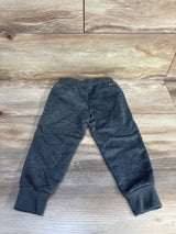 Dark gray kids jogger pants with ribbed cuffs on wood background