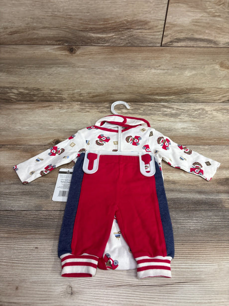 Front view of Baby Starters three piece Sock Monkey bodysuit, pants, and bib set in ivory with red pants on a wood background