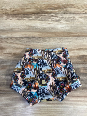 Baby shorts with western-themed print featuring dogs, cacti, cowboy hats, and colorful patterns on wood surface