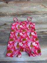 Flat lay of pink Shein x Scooby-Doo shortie romper showing spaghetti straps and all-over heart and Scooby-Doo print on wood plank background