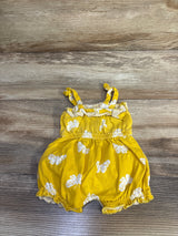 Flat lay newborn yellow shortie romper with white floral print, knotted straps, elastic waist, ruffled legs on wood floor