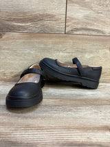 Black kids Mary Jane shoes with thick soles and Velcro strap on wood floor