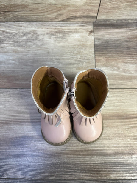 Top-down view of toddler pink round-toe western cowgirl boots showing fringe detail, inner zipper, and stitched sole on wood floor